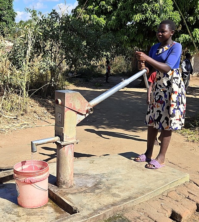 woman at a borehole pump
